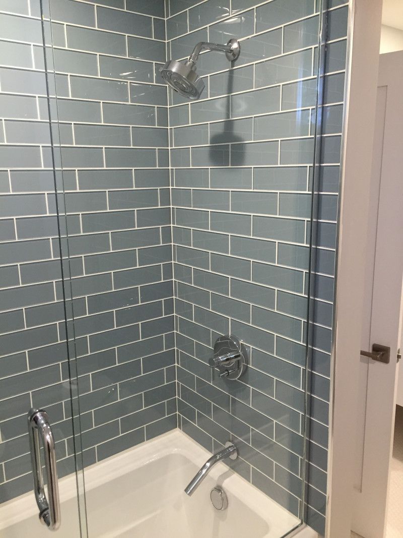 A bathroom with a bathtub and a shower with a glass door.