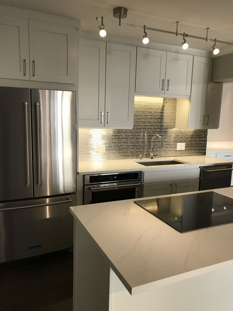 A kitchen with stainless steel appliances and white cabinets