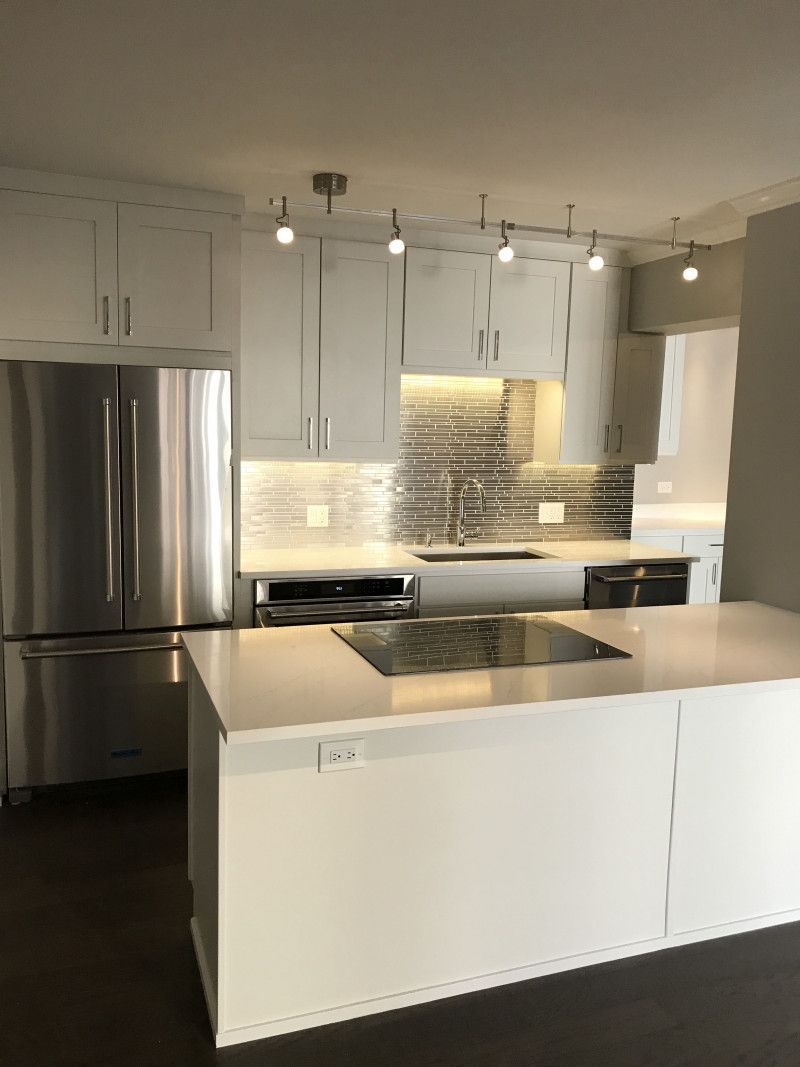 A kitchen with white cabinets and stainless steel appliances