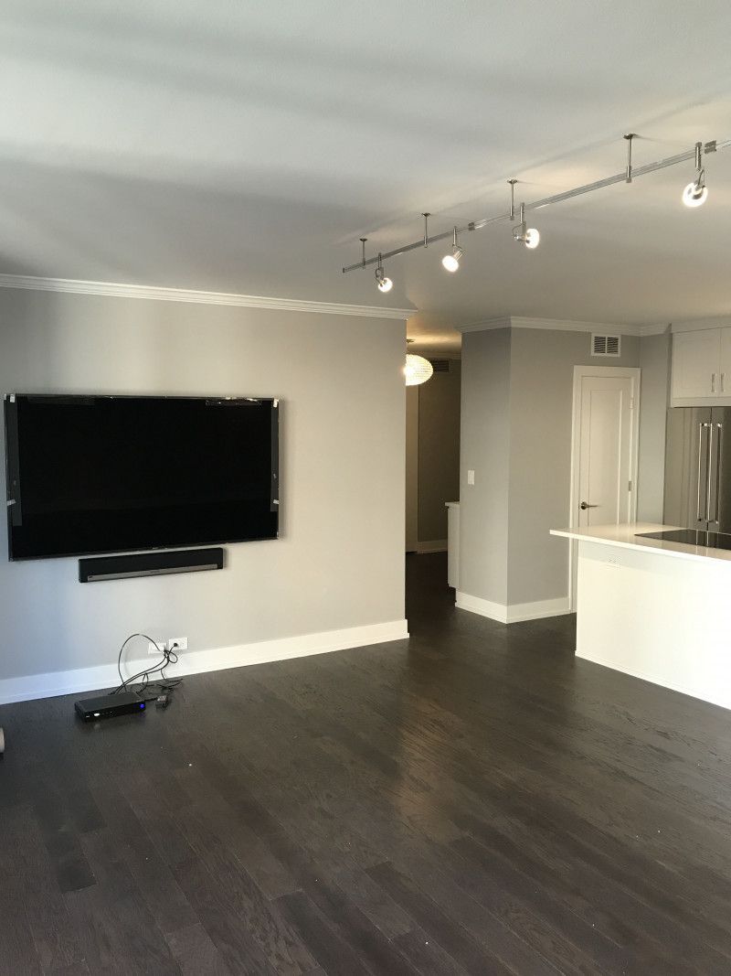 A living room with a flat screen tv on the wall.