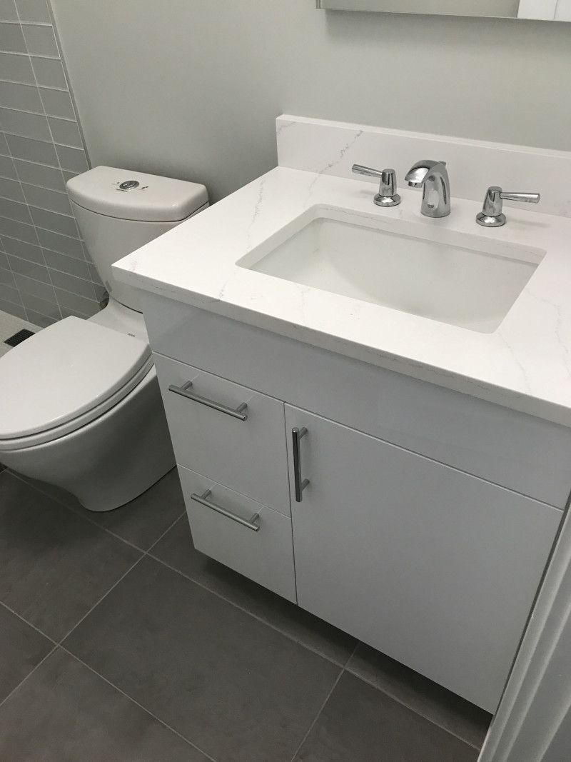 A bathroom with a sink , toilet and mirror.