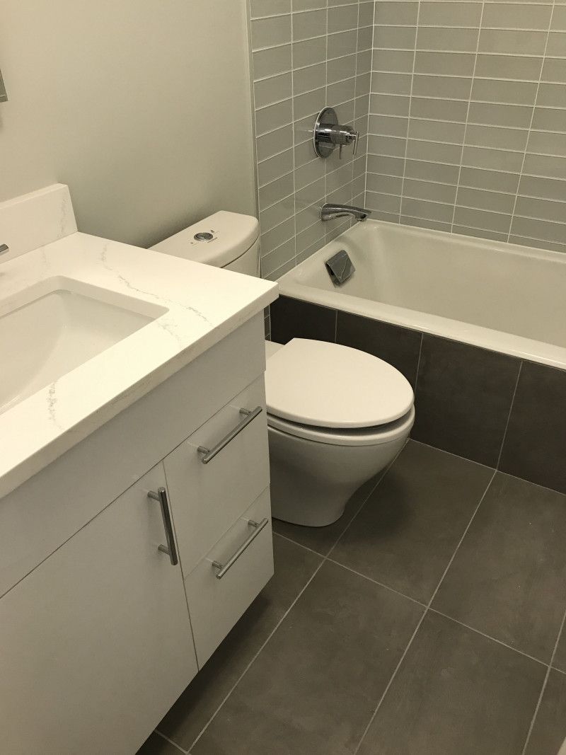 A bathroom with a toilet , sink and bathtub.