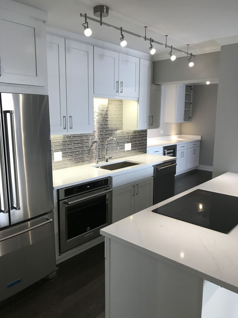 A kitchen with white cabinets and stainless steel appliances