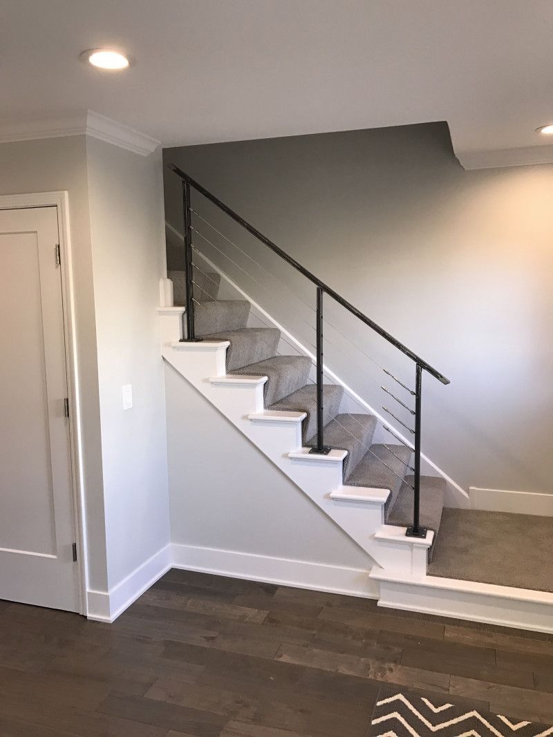 A staircase with a black railing in a living room.