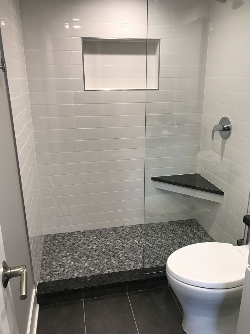 A bathroom with a toilet and a walk in shower.