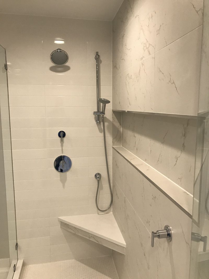 A bathroom with a shower , sink and mirror.