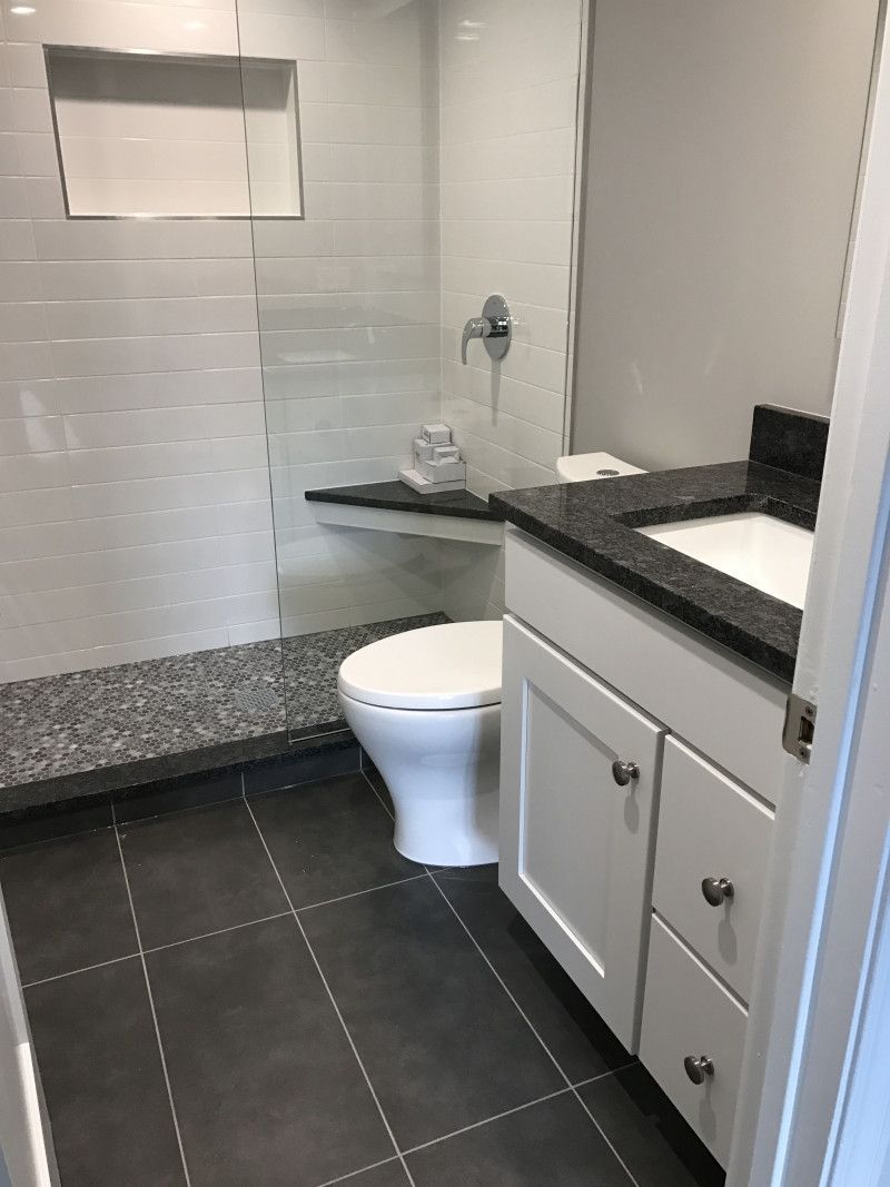 A bathroom with a toilet , sink and shower.
