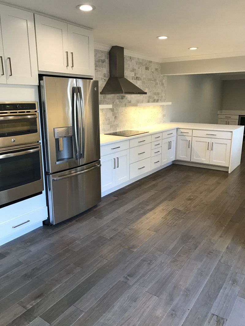 A kitchen with stainless steel appliances and white cabinets.