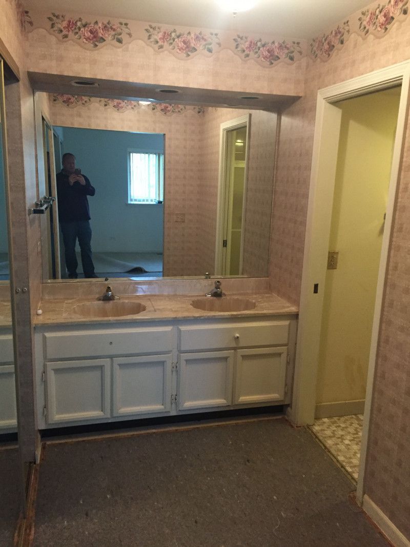 A bathroom with two sinks and a large mirror.