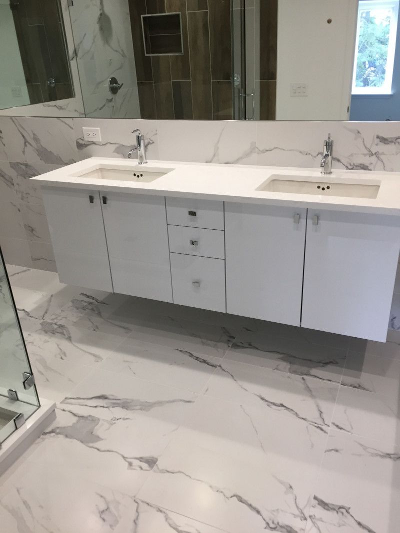 A bathroom with two sinks and a large mirror.