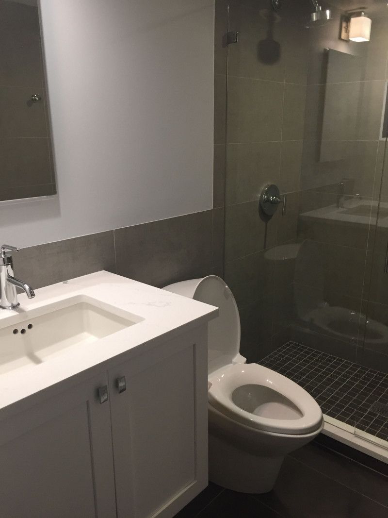 A bathroom with a toilet a sink and a mirror