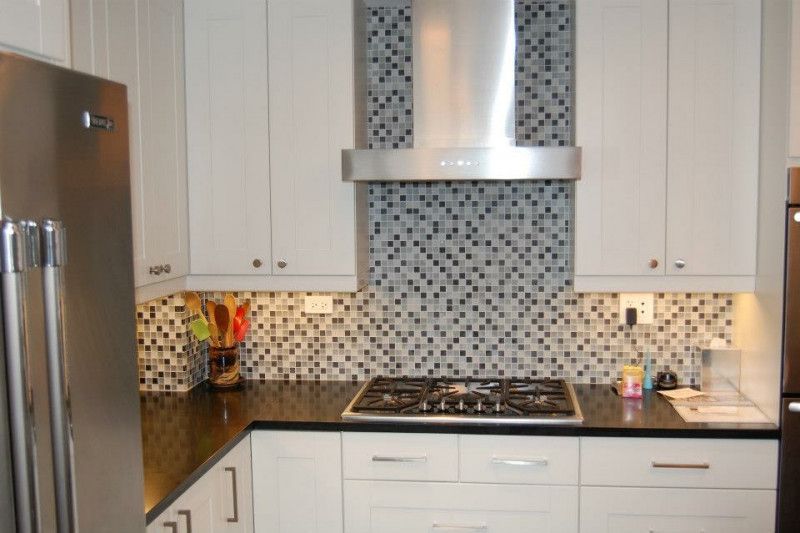 A kitchen with a stove top oven and a refrigerator