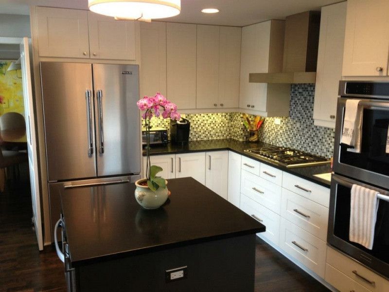 A kitchen with white cabinets and stainless steel appliances