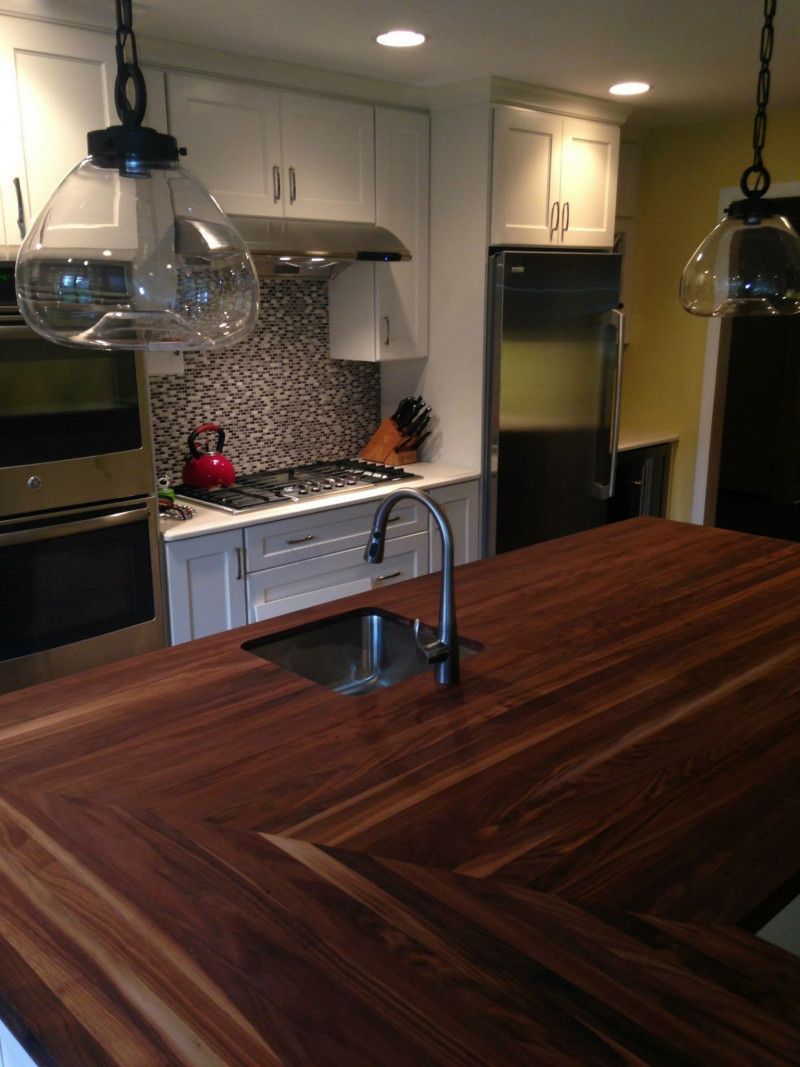 A kitchen with a wooden counter top and a sink
