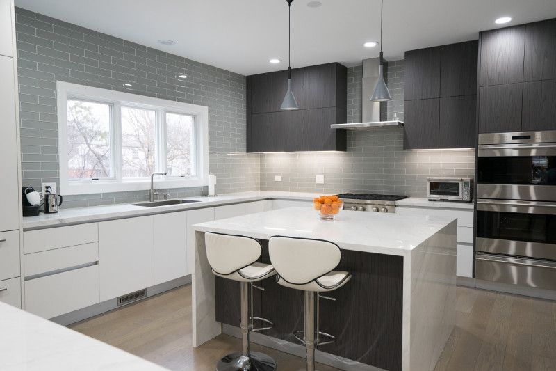 A kitchen with white cabinets and stainless steel appliances and a large island.