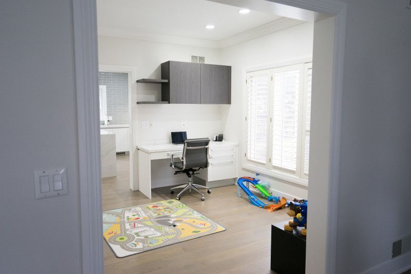 A room with a desk and chair in it and a rug on the floor.