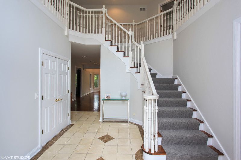 A hallway with stairs leading up to the second floor