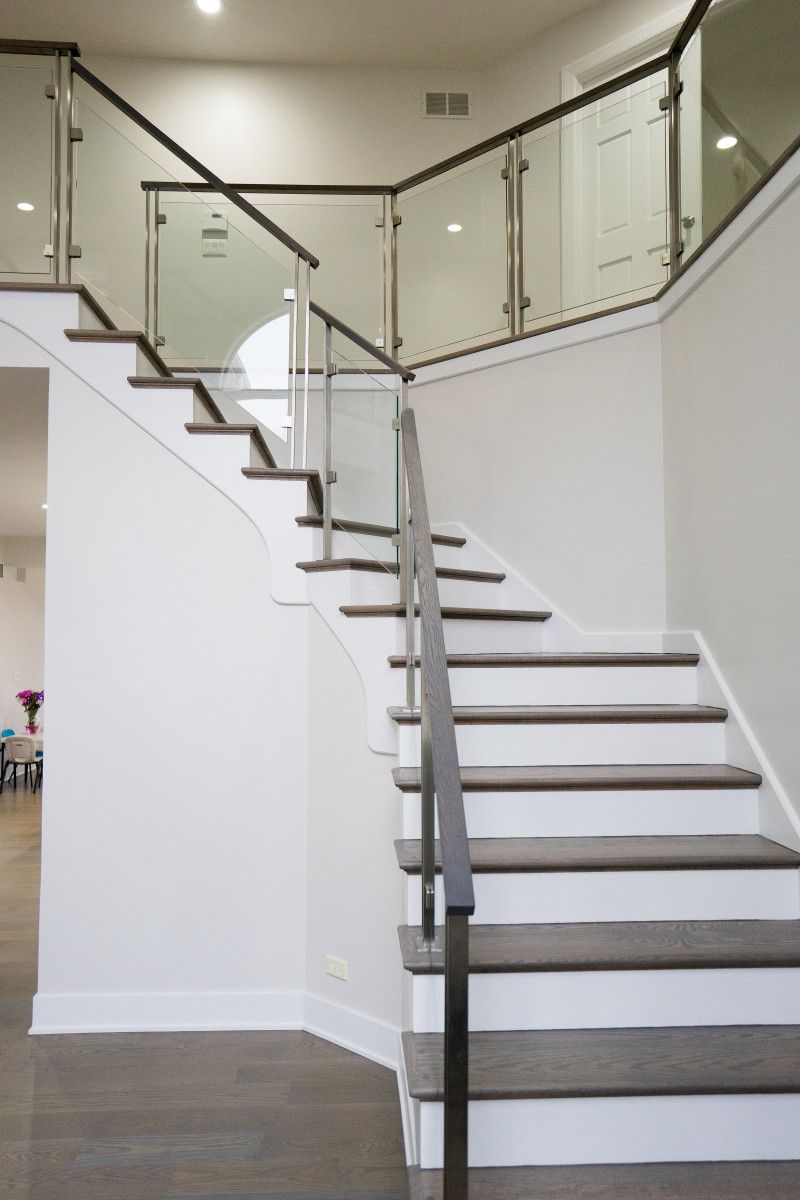 A staircase with white steps and a glass railing