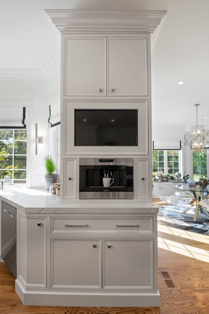 A kitchen with white cabinets and a coffee maker.