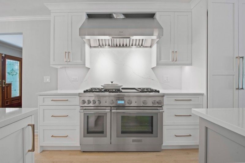 A kitchen with stainless steel appliances and white cabinets.
