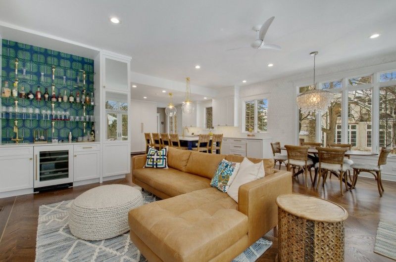 A living room with a brown sectional couch and a ceiling fan.