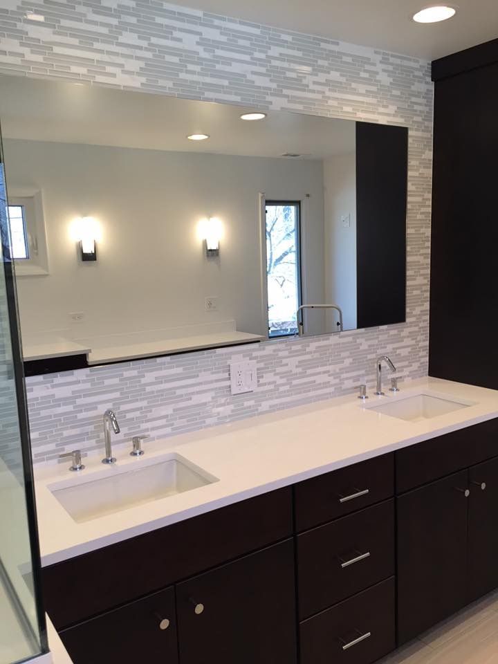 A bathroom with two sinks and a large mirror