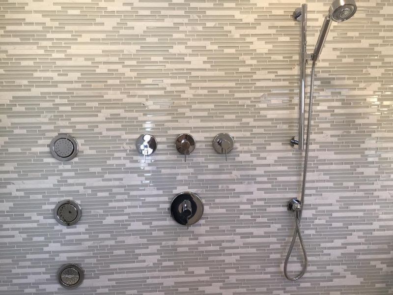 A shower head is hanging from a tiled wall in a bathroom.
