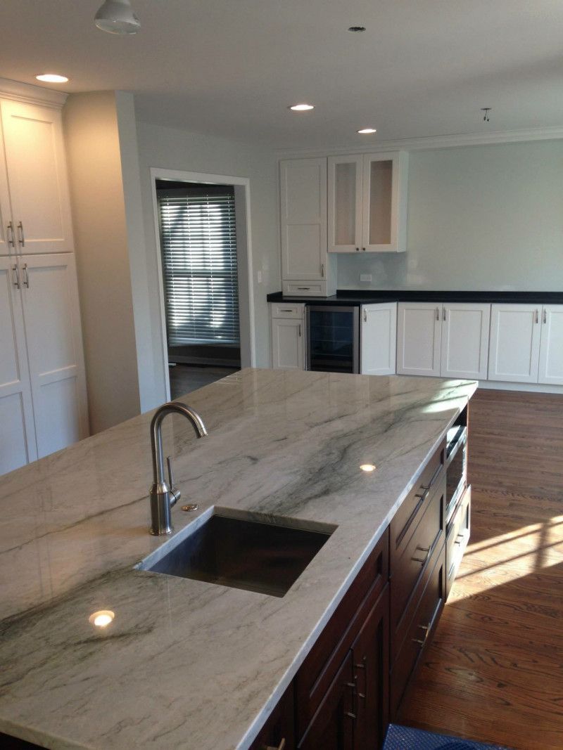 A kitchen with marble counter tops and a sink