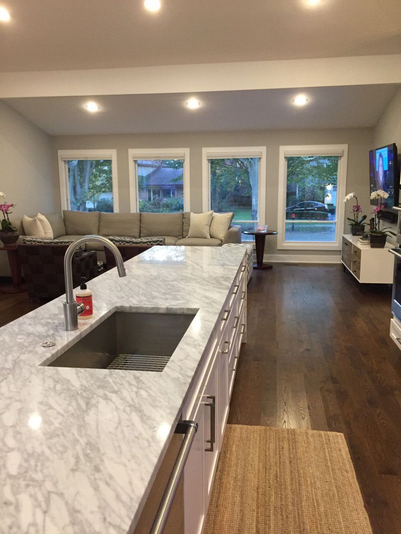 A kitchen with marble counter tops and a stainless steel sink.