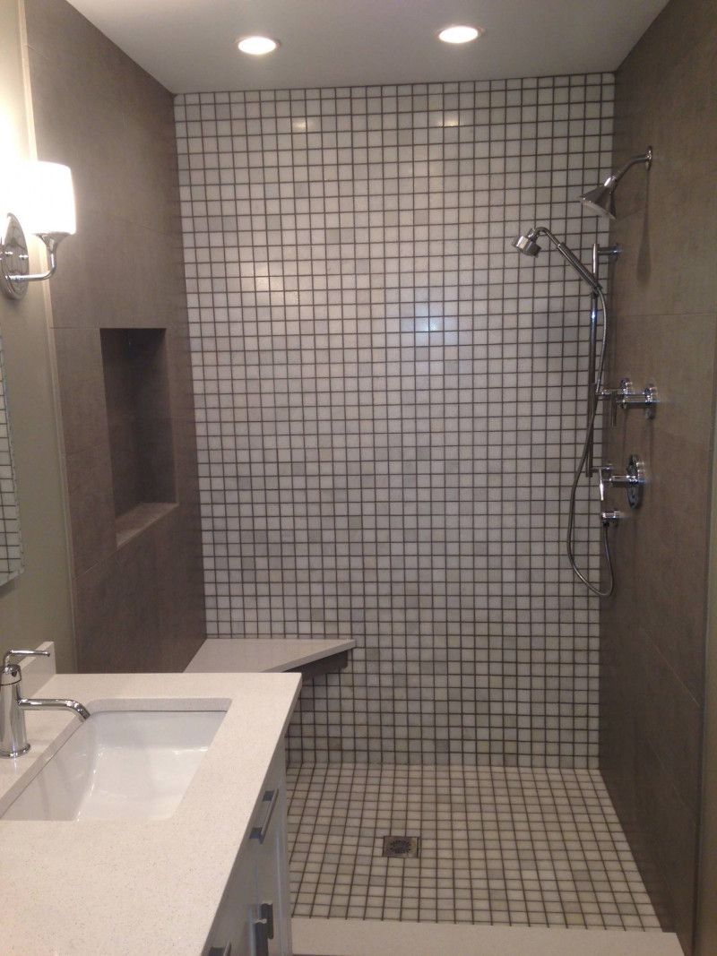 A bathroom with a walk in shower and a sink.