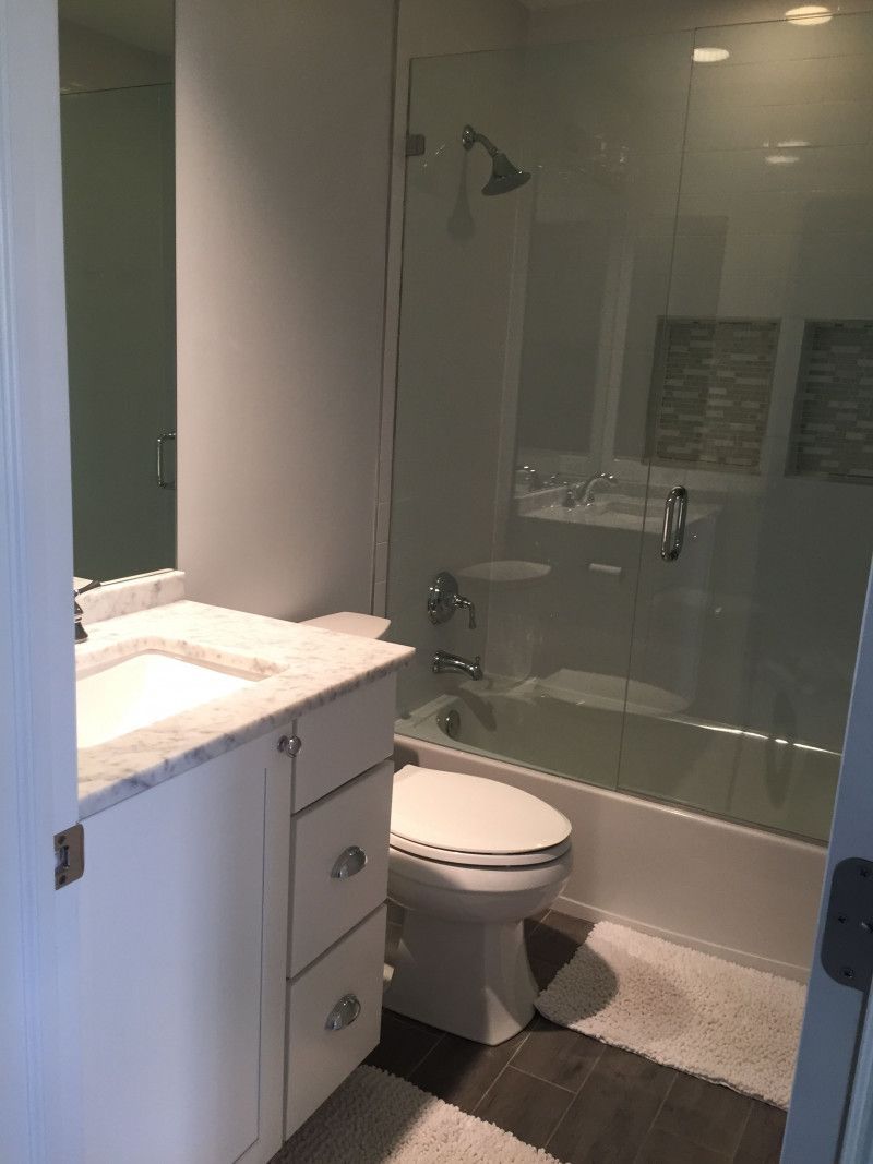 A bathroom with a toilet , sink , bathtub and shower.