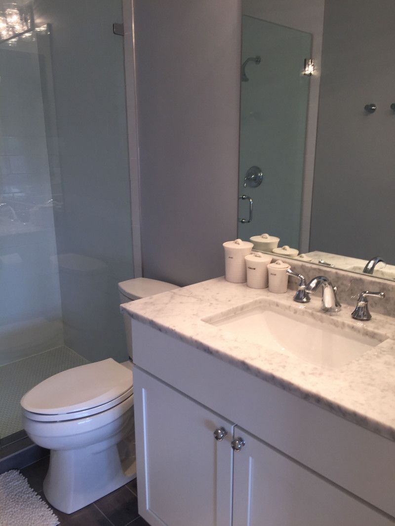 A bathroom with a toilet a sink and a mirror