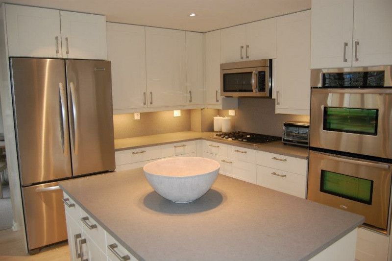 A kitchen with stainless steel appliances and white cabinets