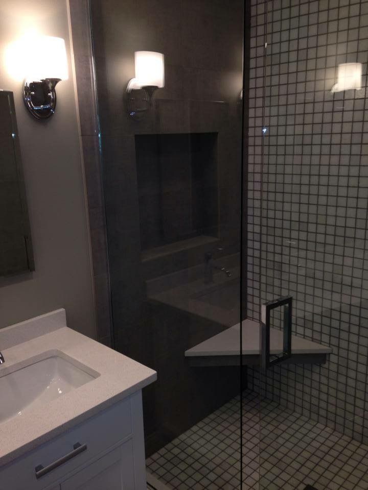 A bathroom with a sink and a walk in shower