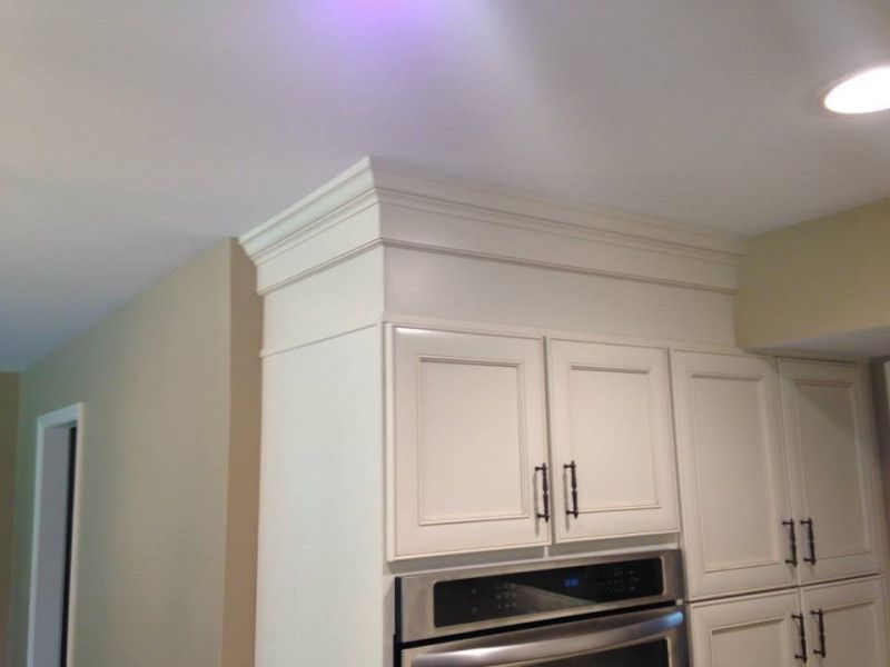 A kitchen with white cabinets and a stainless steel oven.