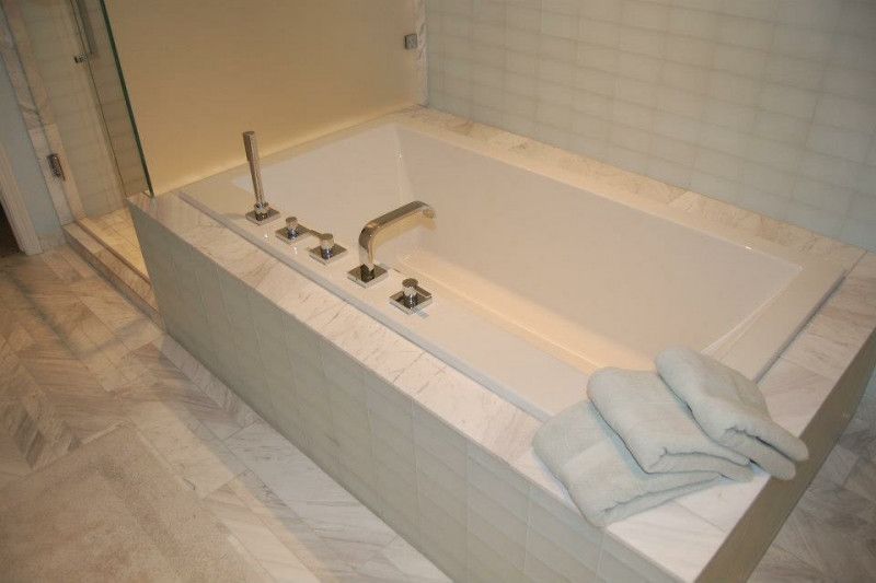 A bathtub in a bathroom with towels on the side