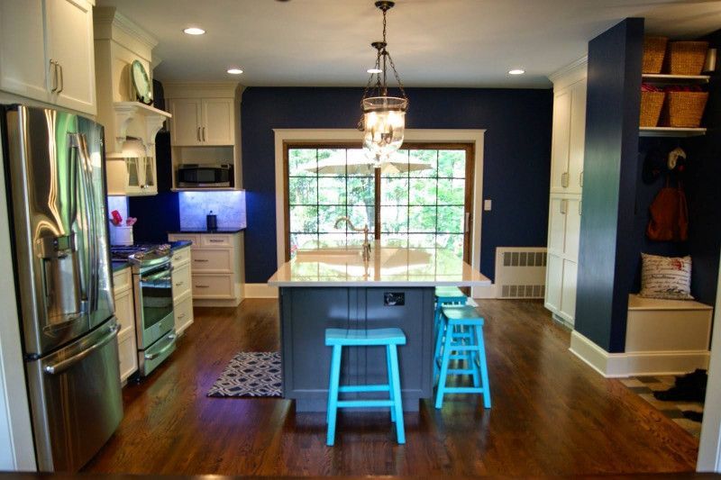 A kitchen with blue stools and a large island