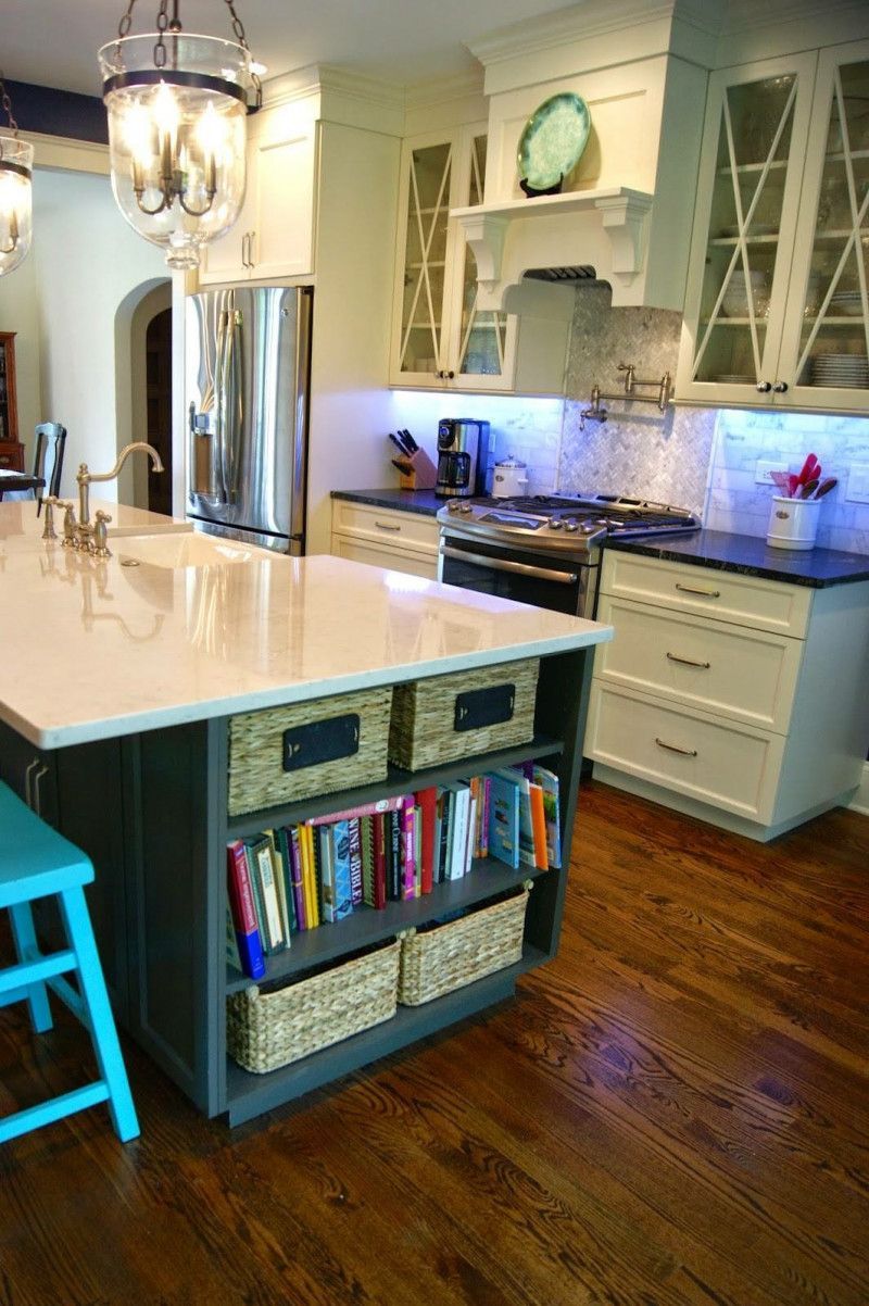 A kitchen with a large island filled with books and baskets