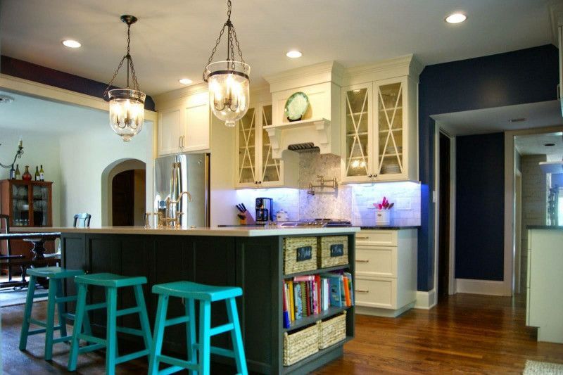 A kitchen with a large island and blue stools