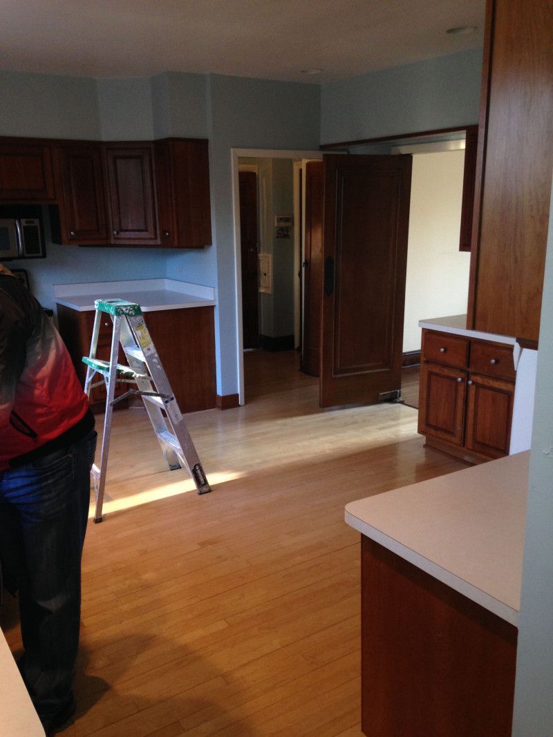 A woman is standing in a kitchen next to a ladder