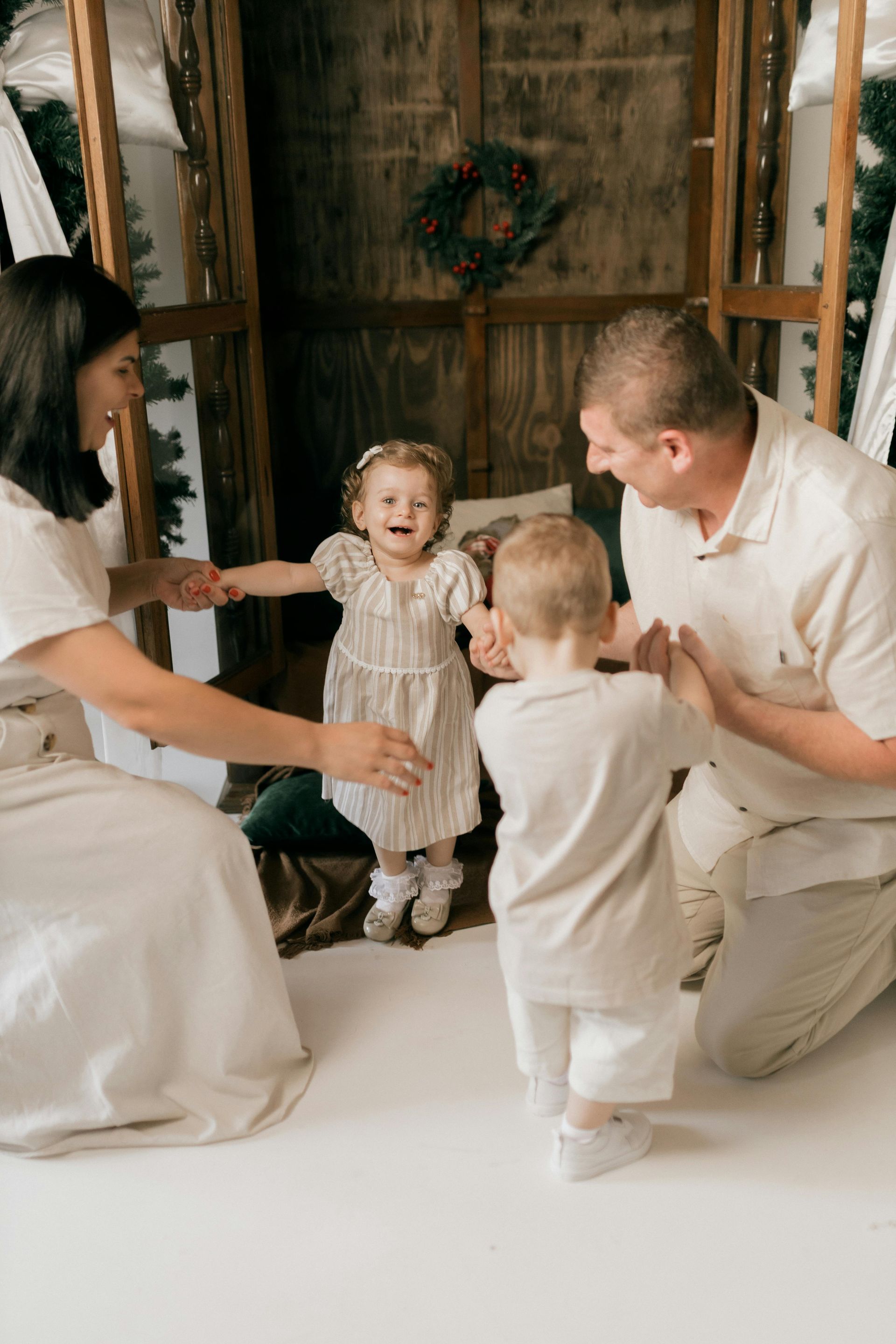 Family dancing together in front of a wooden backdrop. The children are excited and smiling.