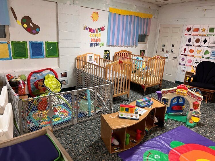 There are many cribs and toys in the room.