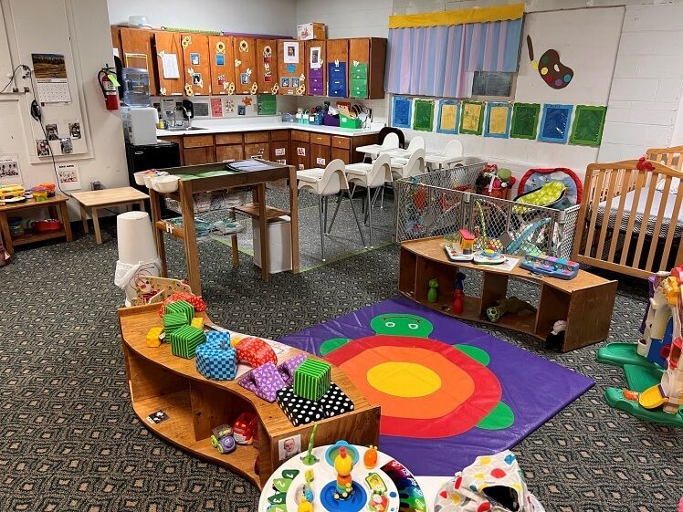 A room filled with lots of toys and a rainbow rug.