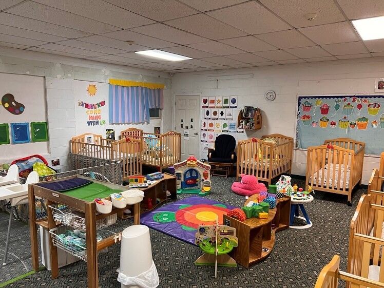 A classroom filled with lots of cribs and toys.