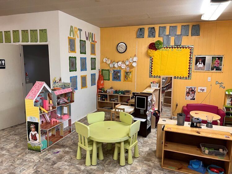 A room with a table and chairs in it and a doll house.