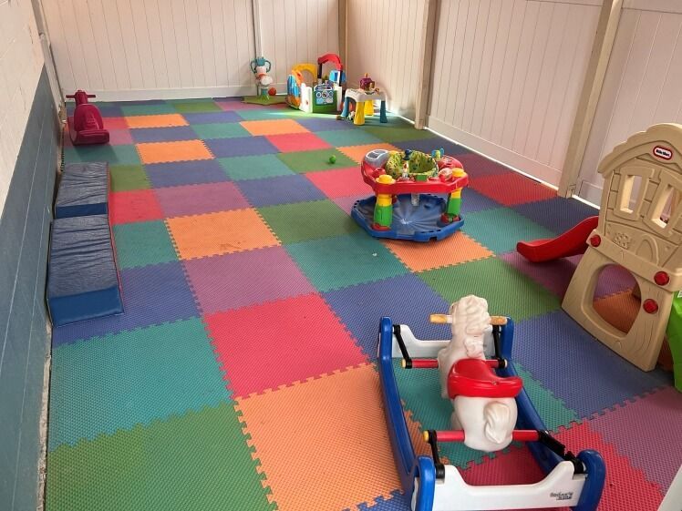 A room filled with lots of toys including a rocking horse