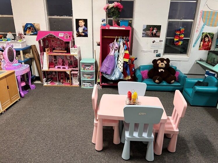 There is a table and chairs in the middle of the room.