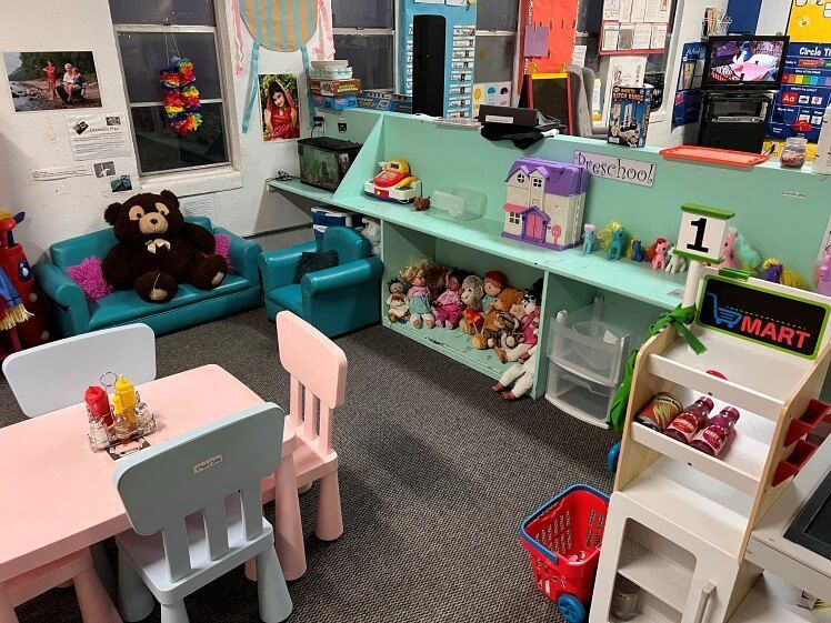 A room filled with lots of toys and a table and chairs.