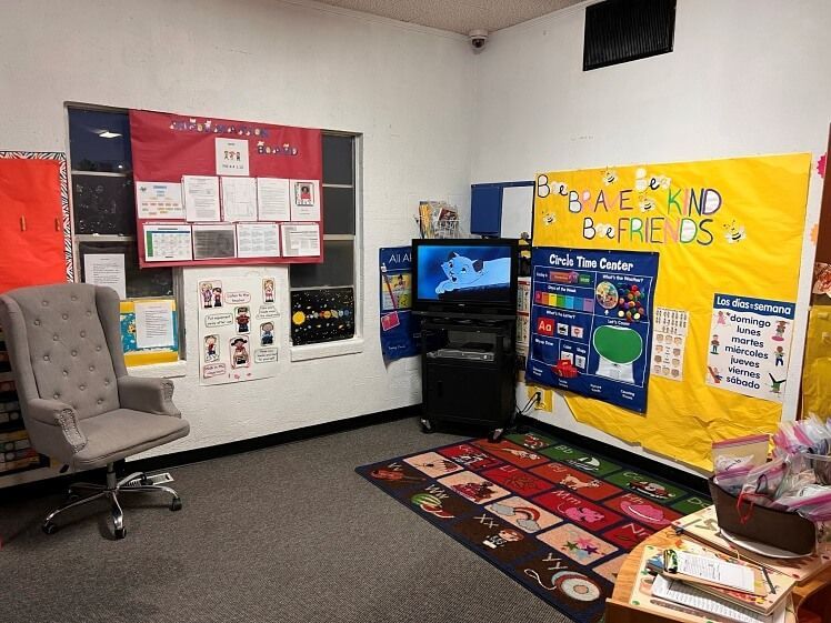A classroom with a chair and a bulletin board that says 