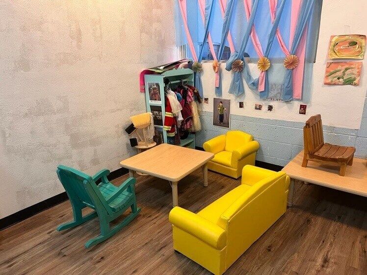 A room with a couch , chairs , tables and a window.